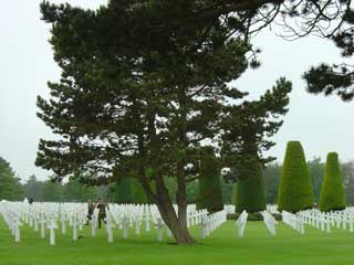 Visiting troops walk amongst the graves at the US cemetery