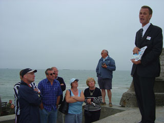 The party listens as Edward describes the construction of the harbour