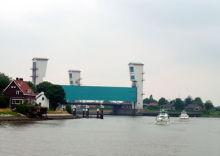 Boats pass under the Algerabrug storm barrier