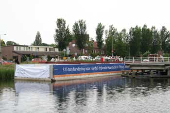 Crowds watch expectantly as the pontoon squeezes through the bridge